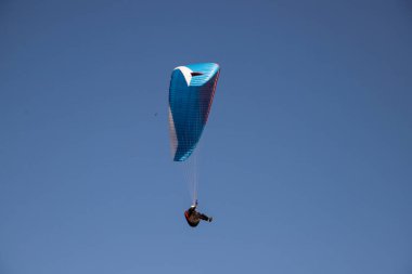 Mavi gökyüzüne karşı yamaç paraşütü Uçan adrenalin ve özgürlük konsepti