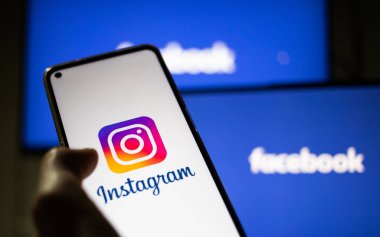 CLUJ-NAPOCA, ROMANIA - ECTOBER 2021: Instagram rrom akıllı telefonu ve bilgisayarına bir kişi giriş yapıyor