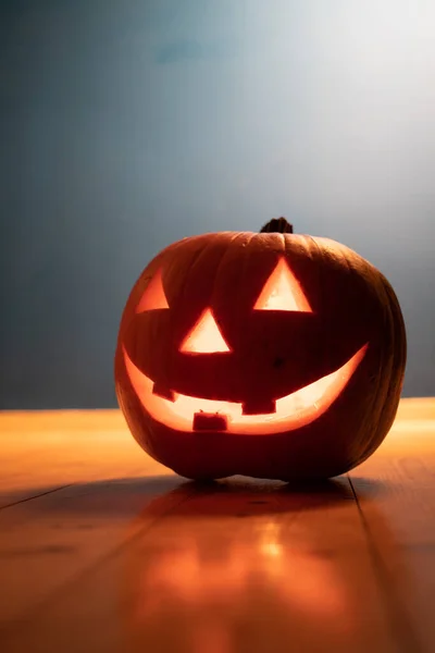 spooky Jack O' Lanterns on wooden table Glowing In Fantasy Night. Halloween Background