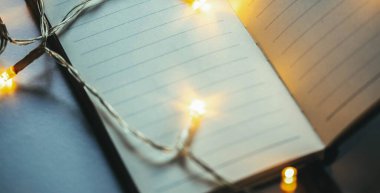 Boş defter üzerindeki noel ışıkları Yeni yıl kararları sayfası