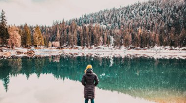 Kışın Caumasee 'nin turkuaz suyunu seyreden kadın İsviçre' de yavaş seyahat ediyor.