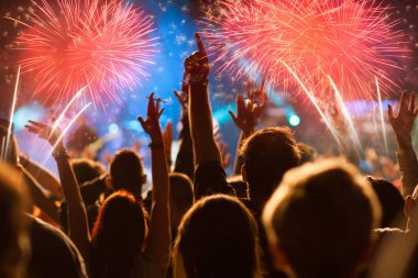 Yılbaşını kutlayan kalabalık havai fişekleri izliyor.