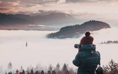 Sırt çantalı ve kameralı adam dağda.