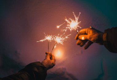 Yılbaşını kutlayan parıldayan yaşlı bir çiftin elleri