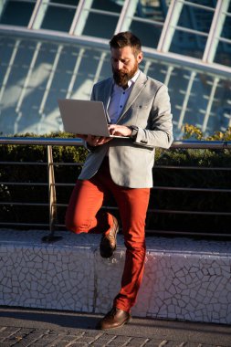 handsome businessman with laptop in the city
