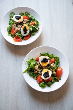 top view of bowls of fresh salad with eggs and caviar
