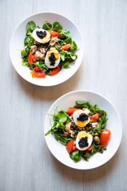 top view of bowls of fresh salad with eggs and caviar