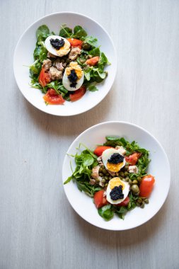 top view of bowls of fresh salad with eggs and caviar