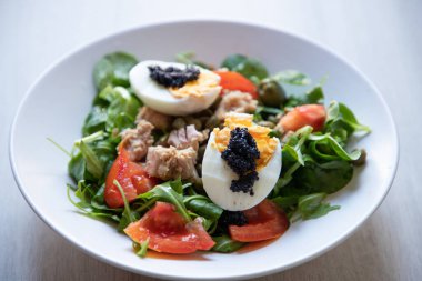 top view of bowls of fresh salad with eggs and caviar