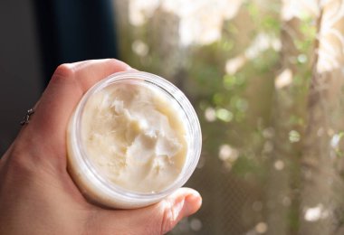 Doğal kozmetik kadın krem tutuyor.