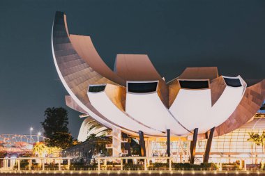 SINGAPORE, SINGAPORE - Mart 2019: Marina Körfezi kumları, Sanat Bilimi müzesi, gökdelenler ve turist tekneleri ile Singapur Marina Körfezi 'nin gece silueti