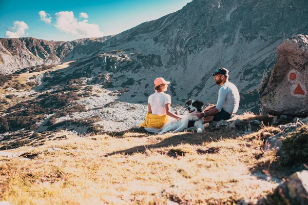 Paar Met Hond Zittend Rotsen Bewonderend Berglandschap — Stockfoto