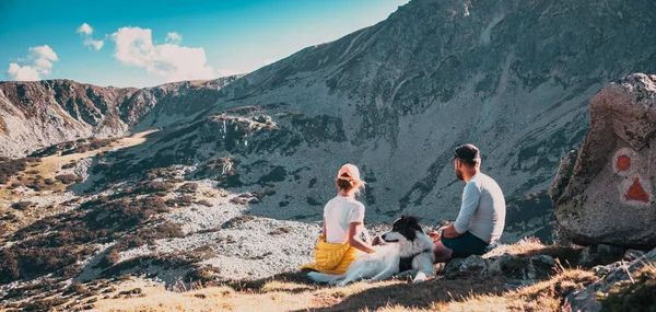 Paar Met Hond Zittend Rotsen Bewonderend Berglandschap — Stockfoto