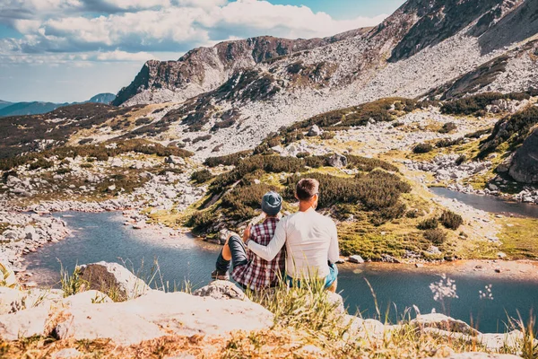 couple sitting on mountain top in amazing summer landscape