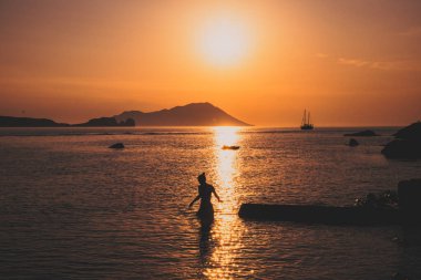 Deniz kenarında teknelerle harika bir gün batımı