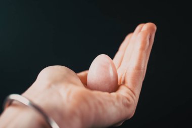 Elinde vajina yumurtası tutan bir kadın. Gül kuvars kristal yeşim yumurtası, uzayı kopyala