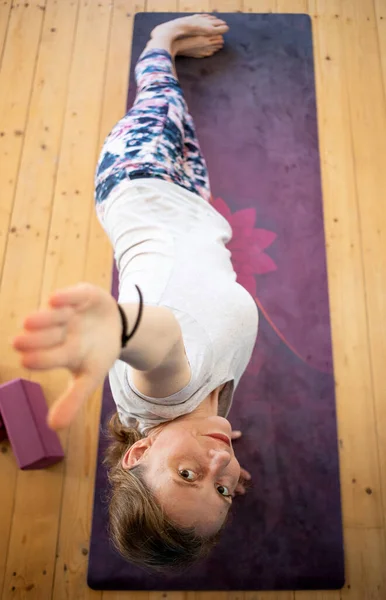 top view of woman doing yoga at home in a side plank balancing pose