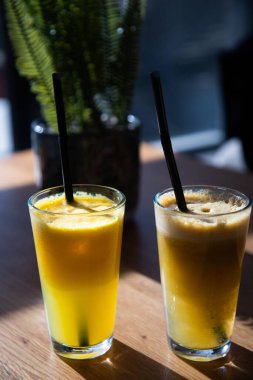 Güneşli bir masada taze portakal veya elma. Sağlıklı yaz içeceği.