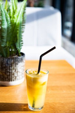 Güneşli bir masada taze portakal veya elma. Sağlıklı yaz içeceği.