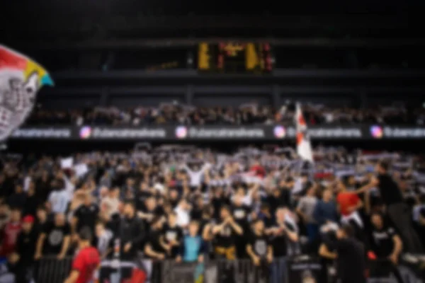blurred background of supporters at sports event crowd of people in a basketball court