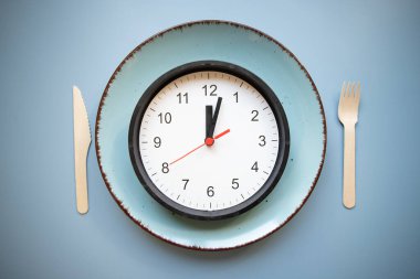 Aralıklı oruç kavramı boş tabak ve saat