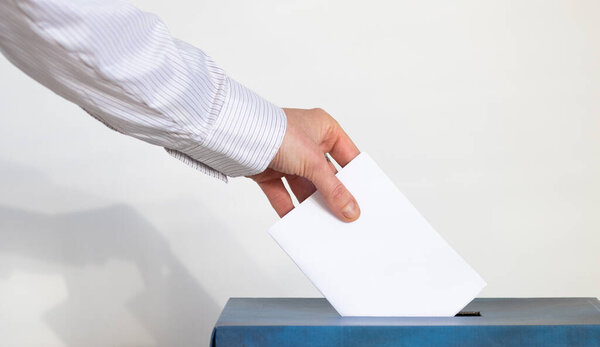 hand putting her vote in a ballot
