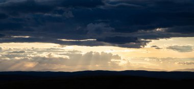 Yazın başında yeşil tepelerin üzerinde gün batımı.