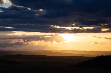 amazing sunset sky over green hills in early summer