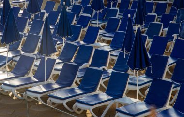 beach chairs and umbrellas near a pool