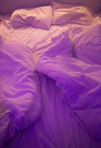 purple ights over bed in cozy home interior