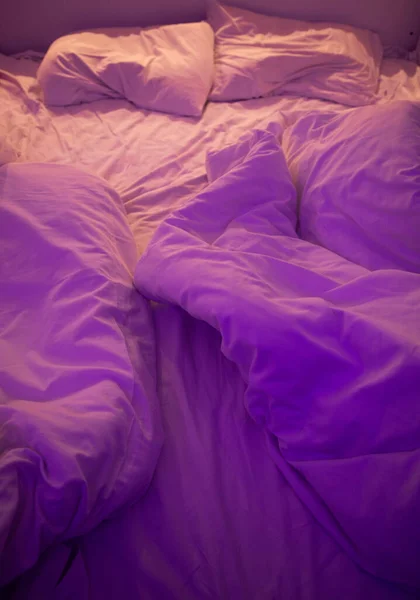 purple ights over bed in cozy home interior