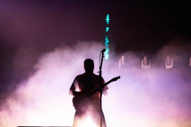 Sahne ışıklarında gitarist silueti