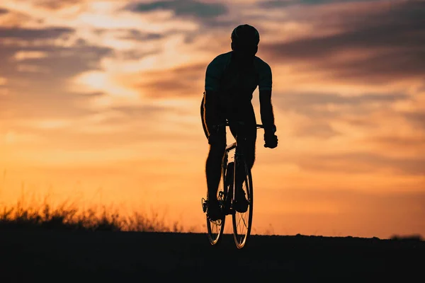 日落时骑自行车的人的轮廓运动和健身的概念 — 图库照片