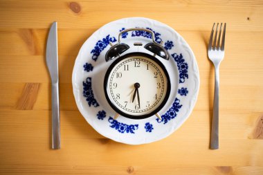 intermittent fasting concept alarm clock on kitchen table