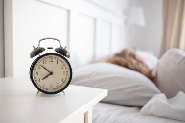 alarm clock and woman sleeping in bed sleep quality