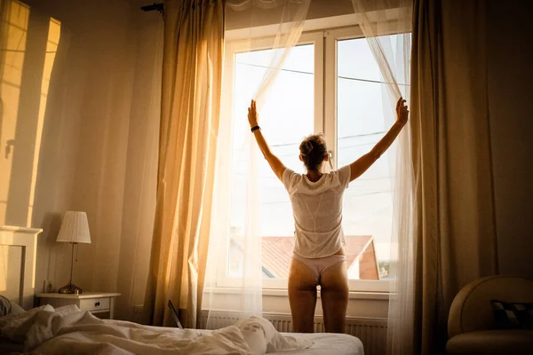 Жінка Відкриває Штори Спальні Яскравому Сході Сонця — стокове фото