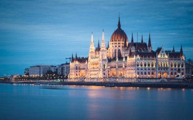Macar Parlamentosu binasının aydınlatıldığı Tuna Nehri 'ndeki Hungary Budapeşte alacakaranlığı