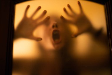 scary picture of hands behind glass, horror ghost woman behind door, Halloween  concept