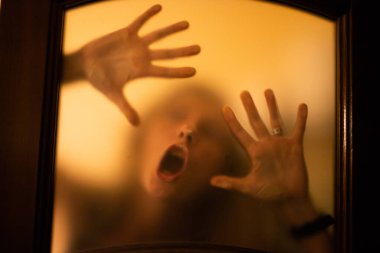 scary picture of hands behind glass, horror ghost woman behind door, Halloween  concept