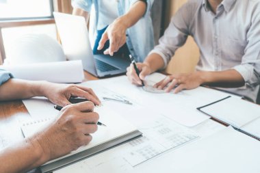 Bir ofiste bir tablet bilgisayardaki bilgileri denetlenirken bir plan mühendisleri tartışmak.