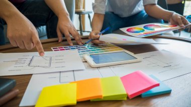 Grafiksel tasarım, renk örnekleri ve kalemler bir masanın üzerinde. Çalışma araçları ve aksesuarları olan mimari çizimler.