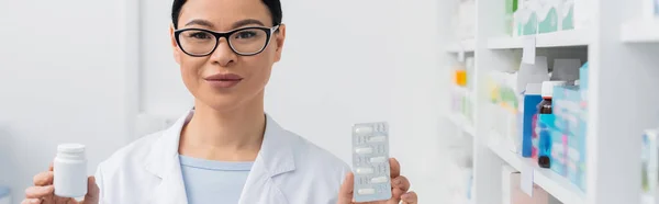 Heureux Asiatique Pharmacien Tenant Bouteille Blister Pack Avec Médicament Bannière — Photo