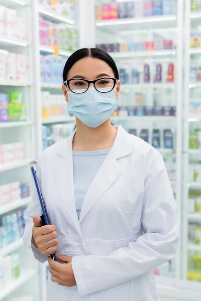 Asian Pharmacist Glasses Medical Mask Holding Clipboard Drugstore — Stock Photo, Image