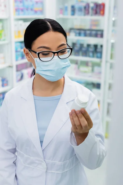 Asian Pharmacist Glasses Medical Mask Looking Bottle Pills — Stock Photo, Image