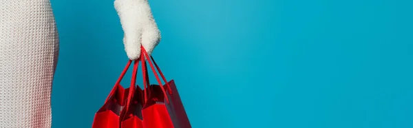 Cropped View Woman Glove Holding Red Shopping Bags Isolated Blue — Stock Photo, Image