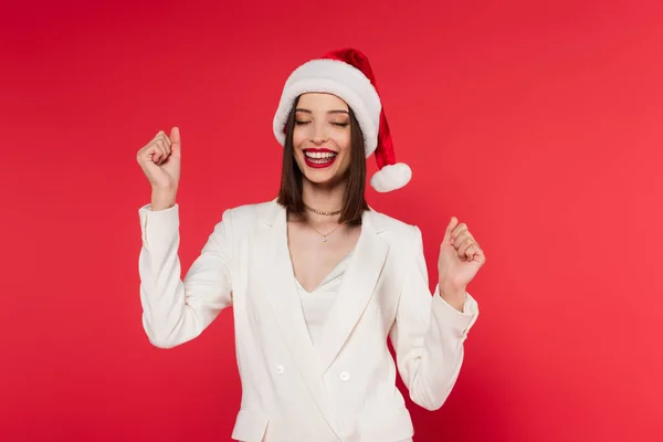 Aufgeregte Frau Mit Weihnachtsmannmütze Und Weißer Jacke Zeigt Geste — Stockfoto