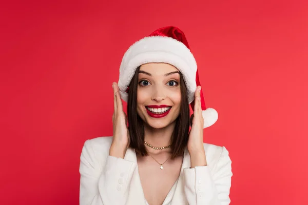 Noel Baba Şapkası Beyaz Ceketli Heyecanlı Kadın Kırmızı Kameraya Bakıyor — Stok fotoğraf