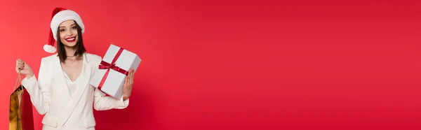 Молода Жінка Червоними Губами Капелюхом Санти Тримає Сумку Покупок Присутня — стокове фото