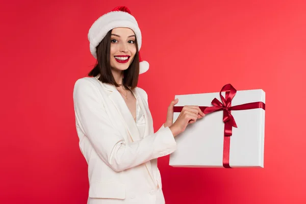 Mujer Sonriente Sombrero Santa Celebración Regalo Con Arco Aislado Rojo —  Fotos de Stock