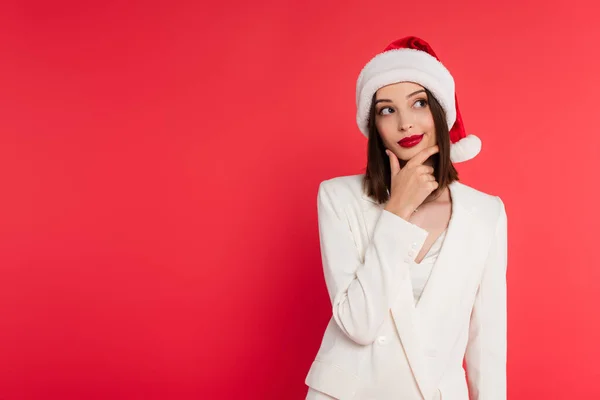 Nachdenkliche Frau Jacke Und Weihnachtsmütze Auf Rot — Stockfoto